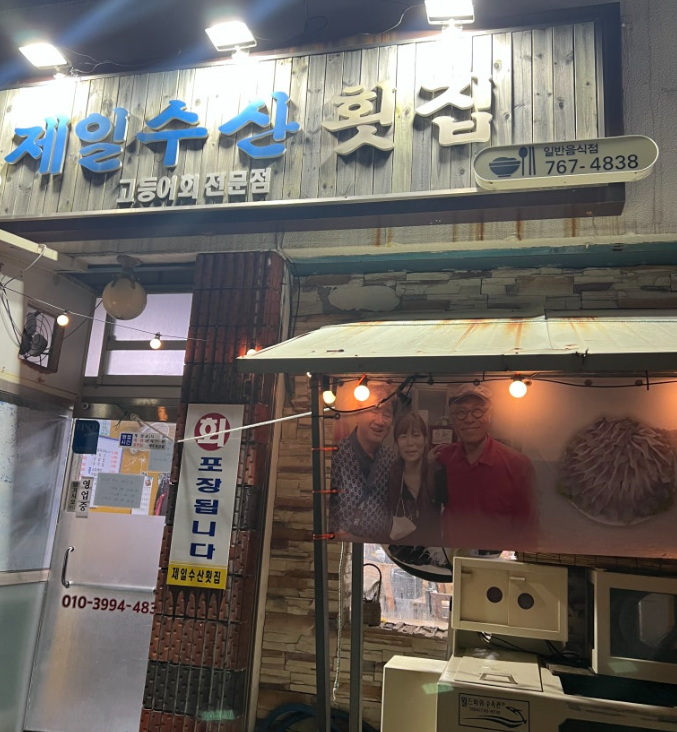 밤거리 간판에 제일수산횟집, 고등어회 전문점, 767-4838이 적힌 외관